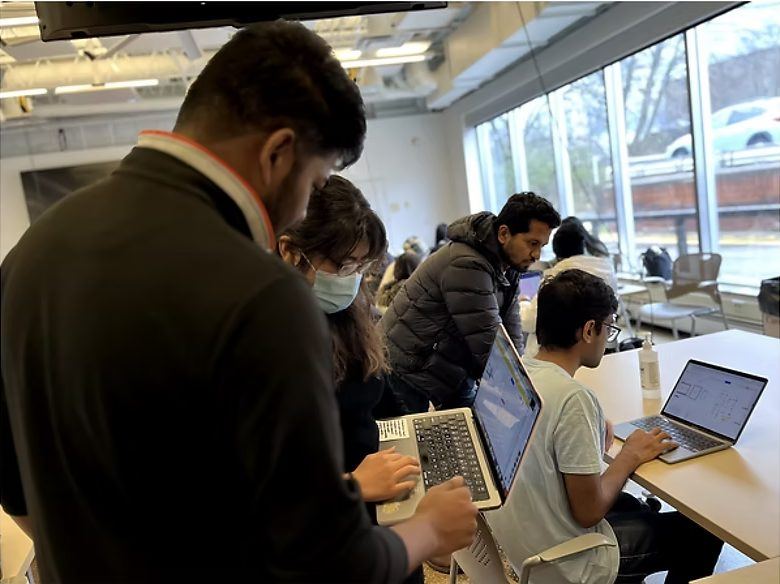 A team member observing students on laptops during co-design